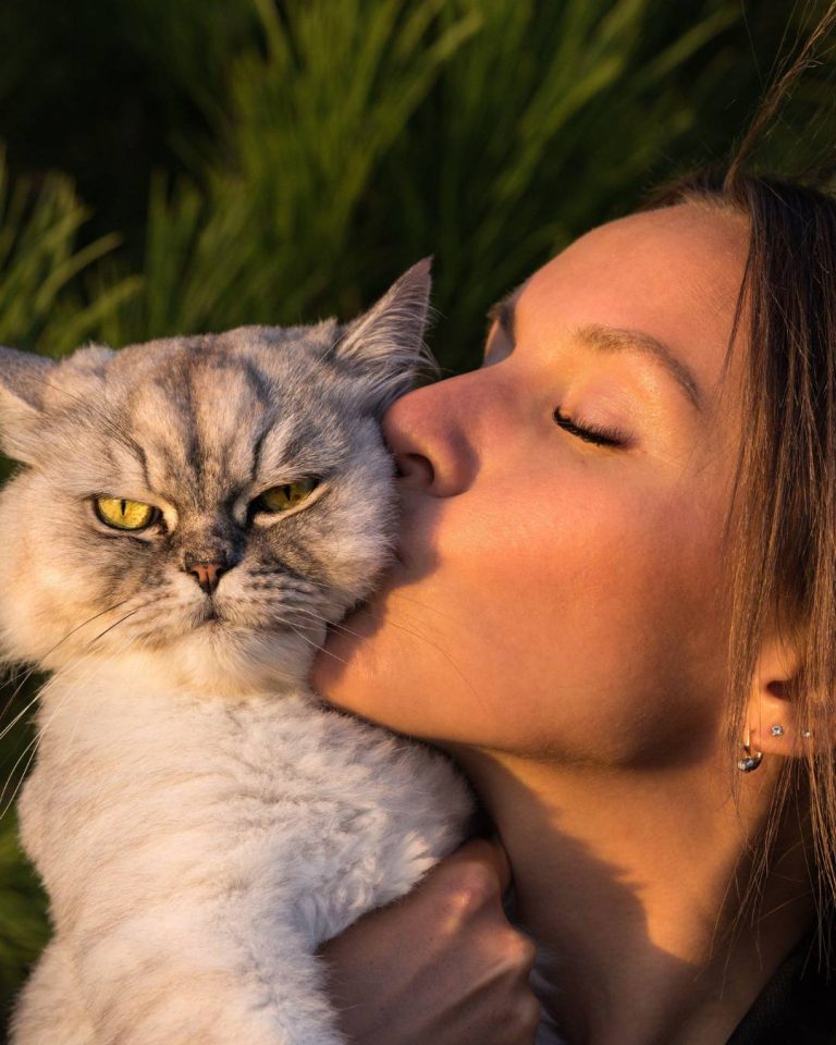 woman kissing her cat, not worried about her dating life